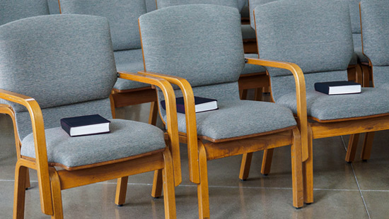 Interior of a sanctuary with hymnals on chairs